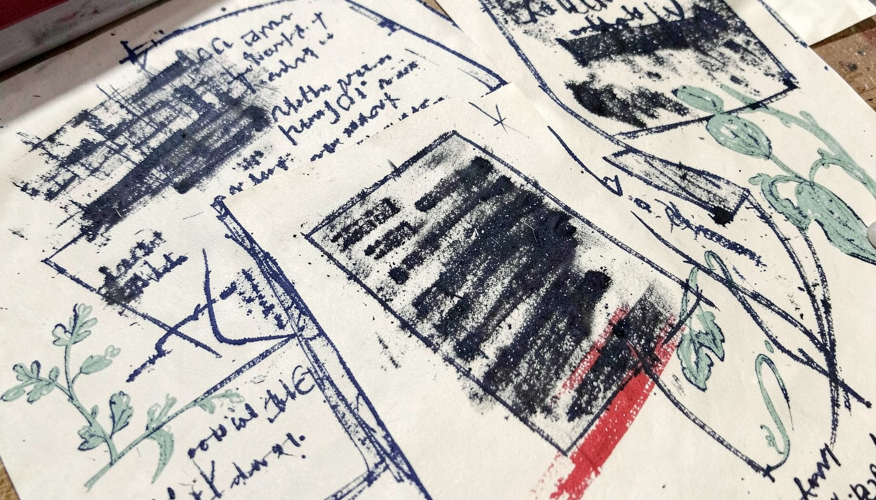 A bold charcoal drawing of handwritten pages scattered across a table, navy ink on cream paper, with soft sage-green botanical elements